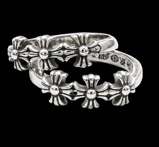A pair of silver-toned metal rings featuring a continuous cross pattern, photographed on a clean white background.